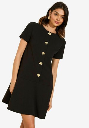Vestido negro de manga corta con botones en forma de hoja dorada, un escote redondo y una falda acampanada. Tejido suave con un acabado texturizado.