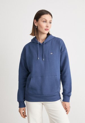 Niebieska bawełniana bluza z kapturem, z regulowanym sznurkiem, kieszenią z przodu i ściągaczami na rękawach. Prosty design z haftowanym logo na klatce piersiowej.