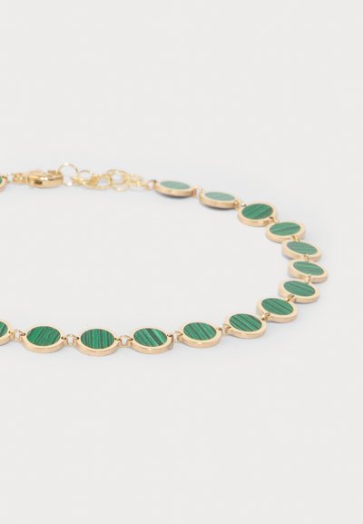 Pulsera en tono dorado que presenta piedras redondas de malaquita alternando con patrones de rayas verdes, unidas por pequeños conectores redondos.