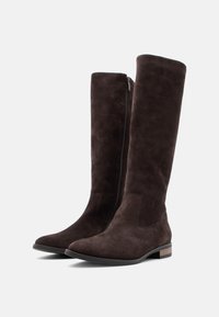 Bruna mockaskinn knähöga stövlar med sidosöm, en spetsig tå och en låg klack med ett trälister på yttersulan.