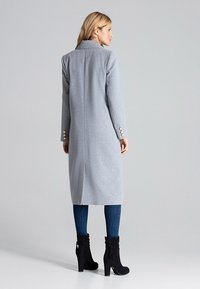 Długi szary płaszcz z teksturowanej tkaniny, z wyciętym kołnierzem, długimi rękawami i złotymi guzikami na mankietach.