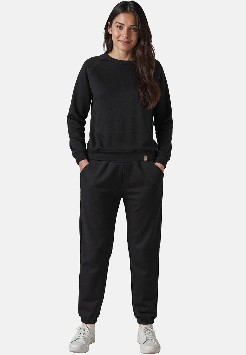 Svart sweatshirt och joggers av mjukt material, med en avslappnad passform, ribbade ärmslut och sidofickor, samt ett märkesaccent på midjebandet.