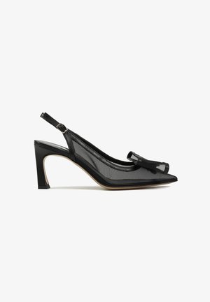 Czarny but na wysokim obcasie typu slingback z ostrym noskiem, siateczkowymi bokami i ozdobną kokardą na górze, przedstawiony na białym tle.