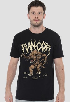 Man wearing black t-shirt with a snarling Rancor creature and the Star Wars logo on the front.