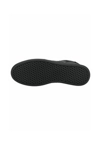 Schwarze Schuhsohle mit strukturiertem Oberflächenmuster, das kleine runde Punkte für einen besseren Grip aufweist. Aus solidem schwarzen Gummi gefertigt und mit einer geschwungenen Form.