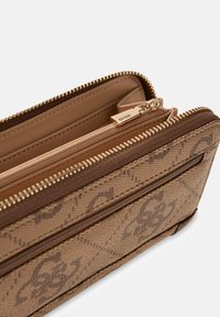 Portafoglio marrone con motivo decorativo, esterno testurizzato, doppio scomparto con zip e dettagli in metallo color oro. Presenta più slot per carte e una fodera liscia.