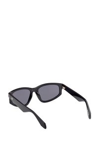 Černé sluneční brýle v kočičím stylu, tmavé čočky, lesklý plastový rám a zlaté detaily na stranách.