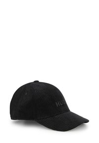Casquette de baseball en velours côtelé noir avec visière courbée et logo en relief sur le devant. Tissu texturé et design structuré avec des accents de couture.