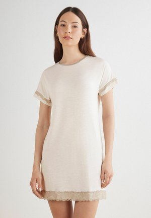 Ljus beige nattklänning i mjukt tyg, med korta ärmar som har spetsdetaljer vid ärmslut och nederkant. Enkel rund halsringning.