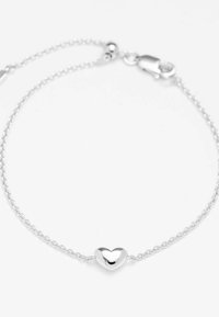 Bracciale in argento con una delicata catena e un ciondolo a forma di cuore curvato. Texture liscia e lucida; dispone di un moschettone per la chiusura.