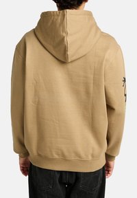 Khaki hoodie featuring a drawstring hood, ribbed cuffs, and back design detail. Soft fabric with a textured finish.