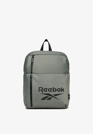 Szary plecak Reebok z dwoma pionowymi kieszeniami na zamek i czarnym logo z przodu, czarna pętla do noszenia na górze.