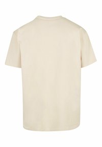 Kræmfaret bomulds t-shirt i lysekræmfarve med korte ærmer, rund halsudskæring og lige kant. Glat tekstur, ingen mønstre eller udsmykninger.