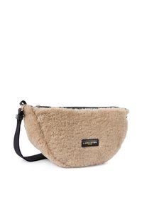 Borsa in pelliccia sintetica beige con forma curvata, chiusura con zip nera e tracolla regolabile nera. Presenta una patch con logo dorato sul fronte.