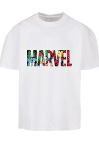 Balts kokvilnas T-krekls ar krāsainu Marvel varoņu grafiku, kas ierakstīta burtiem, kas veido vārdu "MARVEL" uz priekšpuses.