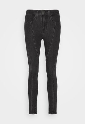 Černé džíny skinny s vysokým pasem, s šikmými postranními švy a dvěma předními kapsami. Hladká textura, přiléhavý střih.