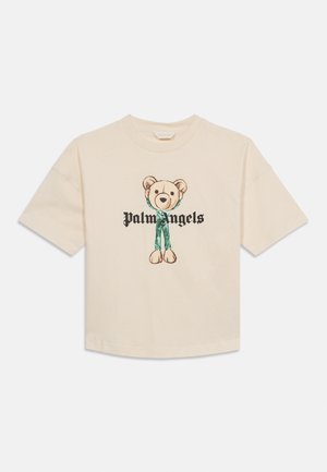 Beige T-shirt met korte mouwen, bedrukt met een afbeelding van een teddybeer met losgeraakte benen en de tekst "Palm Angels" over de borst.