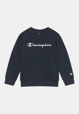 Sweat-shirt bleu marine foncé à manches longues avec logo blanc "Champion" sur la poitrine et petit logo sur le poignet de la manche gauche.