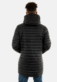 Doudoune noire avec capuche, présentant une texture matelassée et une coupe longue. Le matériau semble résistant à l'eau et léger.
