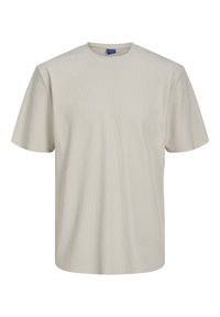 Camiseta de manga corta color beige claro, hecha de un tejido texturizado. Presenta un cuello redondo y un corte relajado sin logos ni patrones visibles.