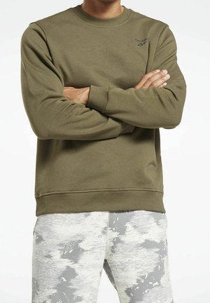 Sweatshirt vert olive en tissu doux, avec un col rond, des poignets et une taille côtelés, portant un petit logo noir sur la poitrine gauche.