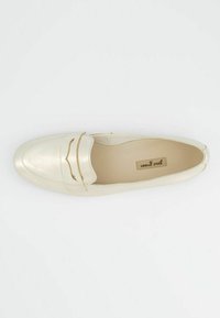 Zlaté metalické kožené mokasíny se zaoblenou špičkou a prošívanými detaily. Interiér má béžové podšívání. Žádné viditelné kovové doplňky.