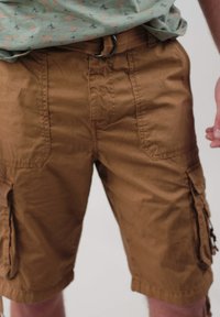 Shorts cargo bruns en coton, dotés de multiples poches latérales, d'une fermeture à bouton et d'une coupe décontractée pour plus de confort.