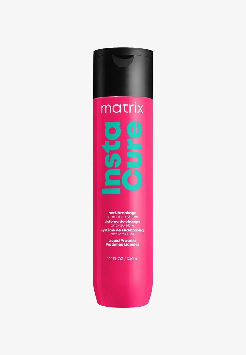 Pink plastic shampoo bottle with a black flip-top lid. Label features "Insta Cure" in bold aqua lettering, detailing ingredients and volume.