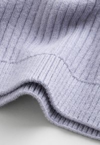 Vaaleanlaventelin värinen ribbikudosmateriaali, jossa on pehmeä tekstuuri ja näkyvät saumat. Sisältää aaltoilevan reunan ja yhtenäisen kuvion koko matkalta.