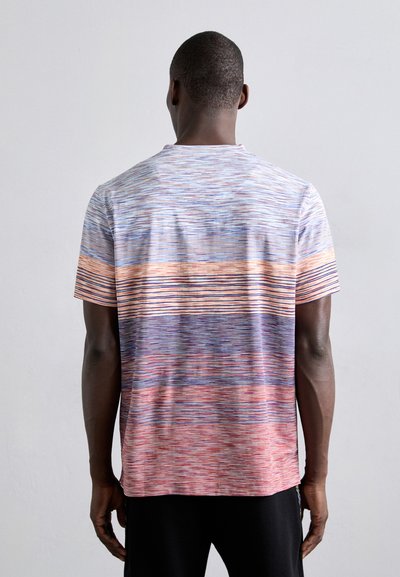 Chemise à manches courtes avec un motif dégradé de lignes horizontales dans des teintes de bleu, rose et orange, fabriquée en tissu léger et texturé.