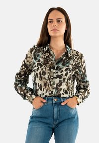 Leopardprint overhemd met knopen in tinten van bruin, crèmekleur en teal, gemaakt van een zachte, lichte stof. Voorzien van een klassieke kraag en lange mouwen.