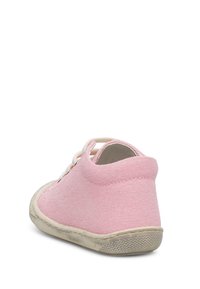 Růžová plátěná bota s kulatým tvarem, bílými tkaničkami a texturovanou gumovou podrážkou. Vyznačuje se pevným podpatkem a opotřebovaným vzhledem podrážky.