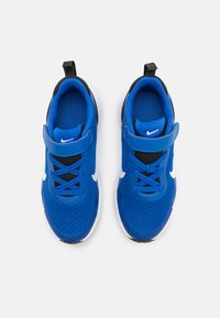 Zapatillas deportivas azules con parte superior de malla, acentos negros, suela blanca y cordones en contraste. Cuenta con una correa de Velcro y detalle de marca.