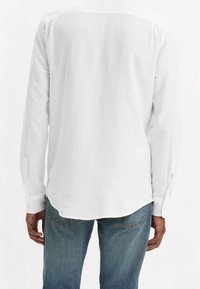 Witte lange mouwen shirt gemaakt van lichtgewicht stof, met een klassieke kraag en met knopen afgewerkte manchetten, een licht gebogen zoom en geen patronen.