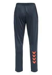 Pantalon de sport bleu marine avec une taille élastique, présentant des accents en chevron orange sur la partie inférieure de la jambe gauche. Confectionné en tissu lisse et léger.