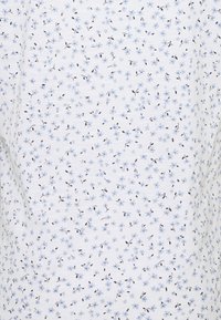 Tela con patrón floral en blanco, con pequeñas flores azules y tallos negros. Textura suave; ligera y adecuada para el uso informal.