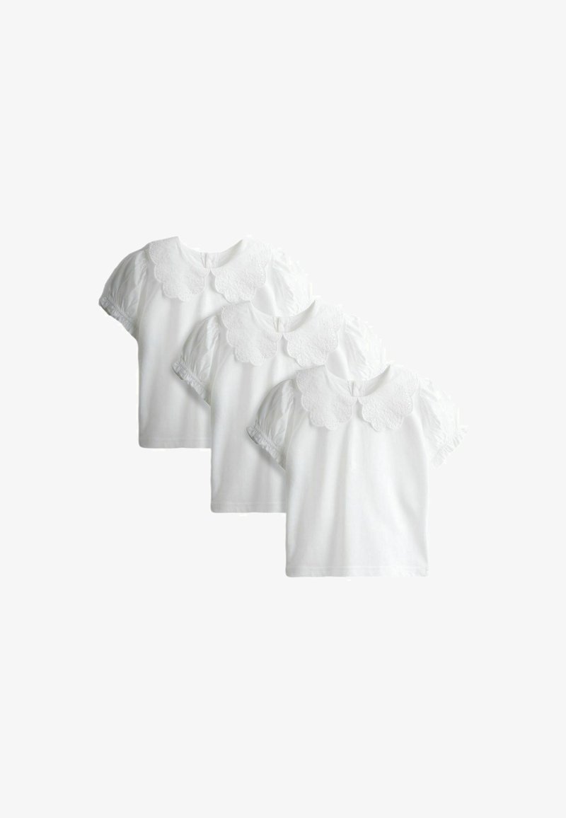 Tre hvide bluser med korte ærmer, skåret i en bølget blonderkrave og med puffede ærmer, arrangeret i et trappestillet, overlappende display.
