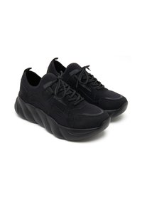 Schwarze Turnschuhe mit einem strukturierten Stoff und glatten Akzenten, ausgestattet mit einer klobigen Sohle mit wellenförmigem Design und einem standardmäßigen Schnürsystem.