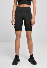 Czarne rowerowe spodenki z wysokim stanem o gładkiej fakturze, z wstawkami z siateczki po bokach i szerokim pasem zapewniającym komfort.