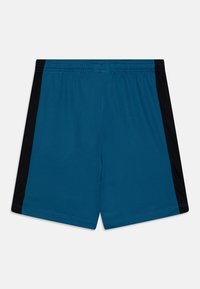 Turkusowe spodenki sportowe z czarnymi panelami bocznymi, elastycznym pasem i gładkim materiałem. Posiadają stebnowane szwy i luźny krój.