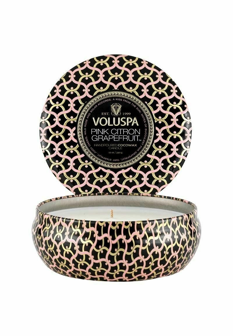 Voluspa handgjuten kokosvaxljus i en svart behållare med rosa och guld geometriska mönster; locket har en matchande design.