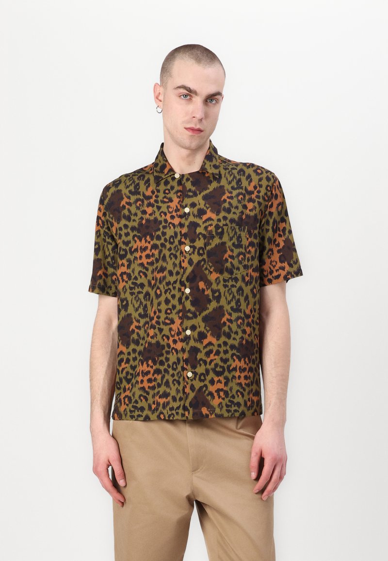 Camisa de manga corta con un patrón de leopardo en verde, negro y naranja, que presenta un frente abotonado y un bolsillo en el pecho.