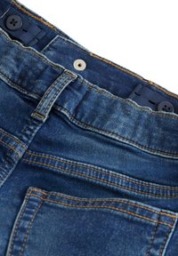 Jeans in denim blu con vita alta, dotati di chiusura abbottonata, dettagli cuciti e una texture morbida e usurata.