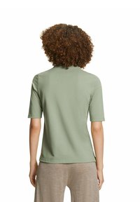 Korte mouwen, mintgroene polo shirt vervaardigd uit zachte katoen, met een kraag en een ontspannen pasvorm. Eenvoudige silhoutte, minimale details.