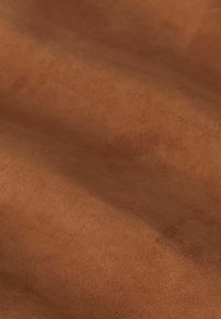 Bruine suede stof met een gladde textuur, met subtiele gradaties. Het materiaal lijkt zacht en buigzaam, ideaal voor verschillende toepassingen.