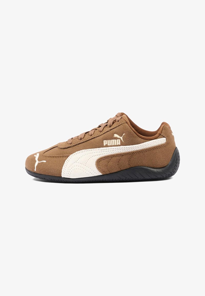 Καφέ σουέντ αθλητικό παπούτσι Puma με λευκό λογότυπο και ρίγα, μαύρη σόλα και σχέδιο με κορδόνια, εμφανιζόμενο από την εξωτερική πλευρά.