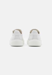 Sneakers bianche con tomaia in pelle liscia, forma arrotondata, suola in gomma testurizzata e design minimalista senza branding visibile.