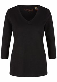 Chemise noire pour femme à col en V, manches longues 3/4 et coupe ajustée, taille 36, avec une petite étiquette en coton biologique à l'intérieur du col.