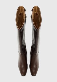 Bottes en cuir marron jusqu'aux genoux avec bouts carrés, tige lisse, doublure intérieure en tan et fermetures éclair sur le côté pour un enfilage facile.