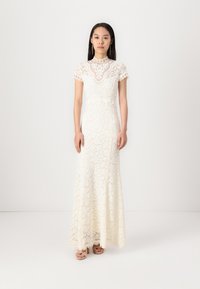 Pakaian malam renda berwarna putih gading, dengan lengan pendek, bodice yang pas, dan rok melebar, serta motif bunga yang rumit di seluruhnya.